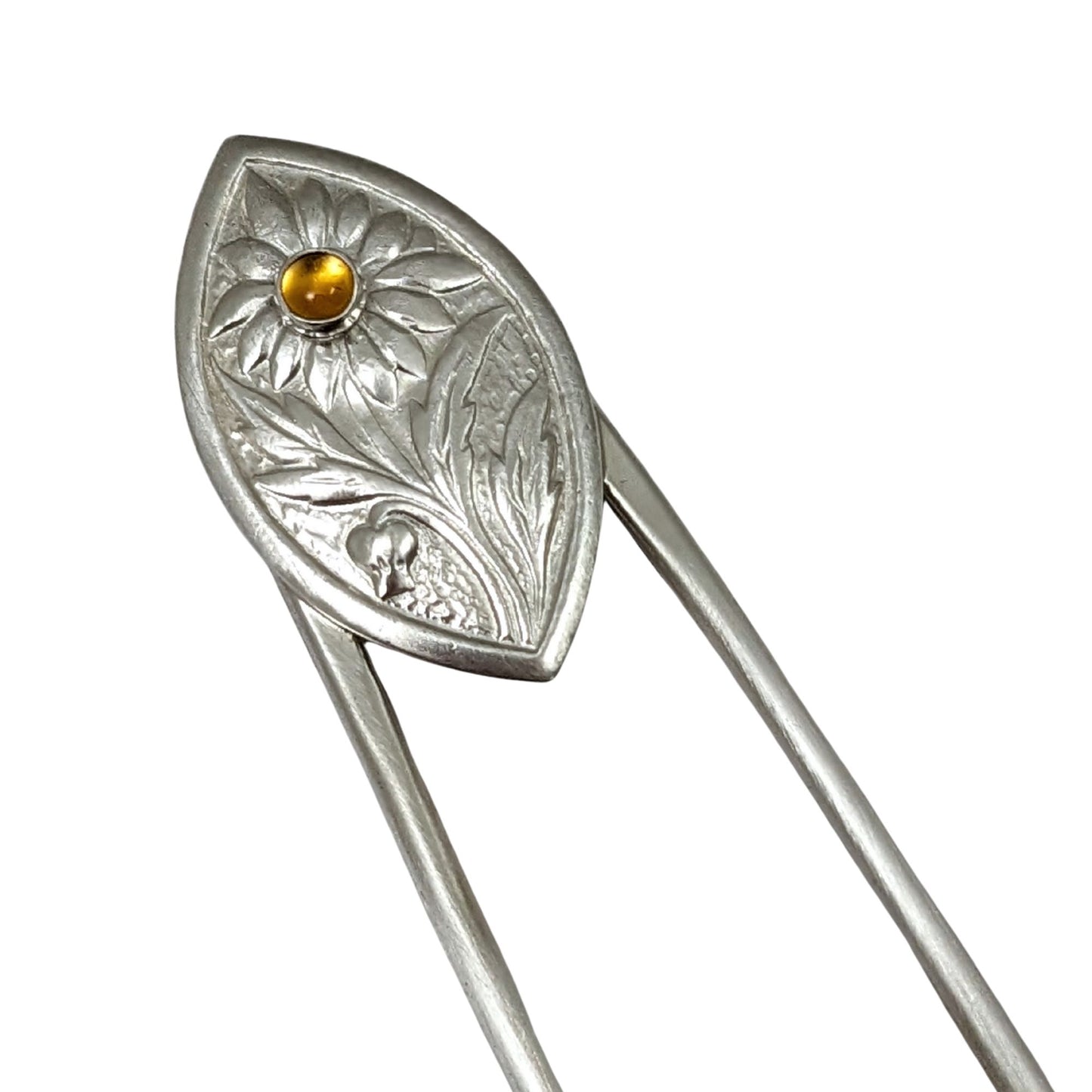 Sterling silver hair fork. The design at the top is a framed pointed oval with a sunflower plant scene. There is a yellow citrine gemstone in the middle of the sunflower.