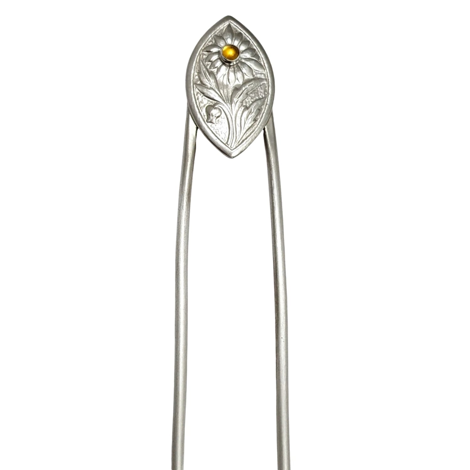 Sterling silver hair fork. The design at the top is a framed pointed oval with a sunflower plant scene. There is a yellow citrine gemstone in the middle of the sunflower.