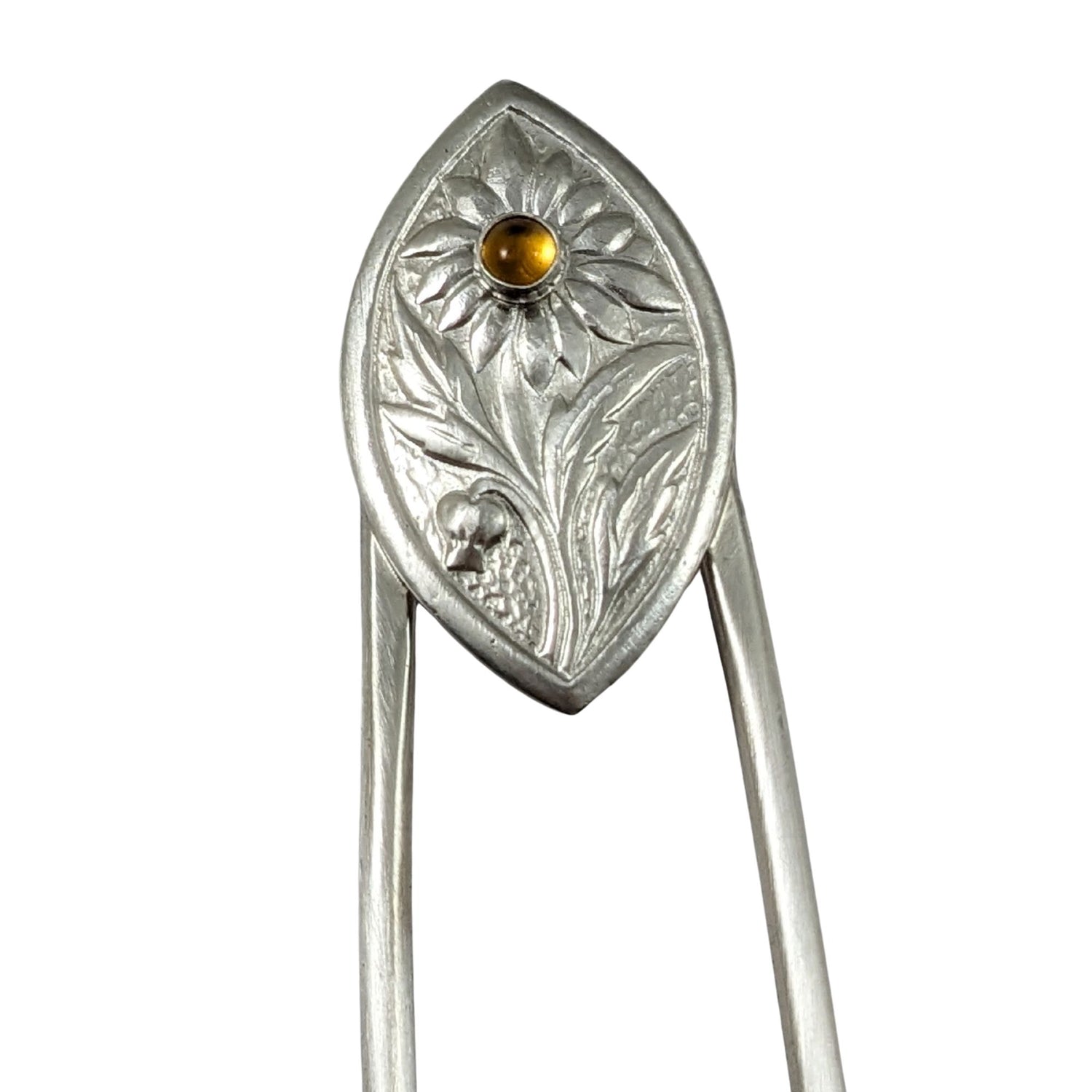 Sterling silver hair fork. The design at the top is a framed pointed oval with a sunflower plant scene. There is a yellow citrine gemstone in the middle of the sunflower.