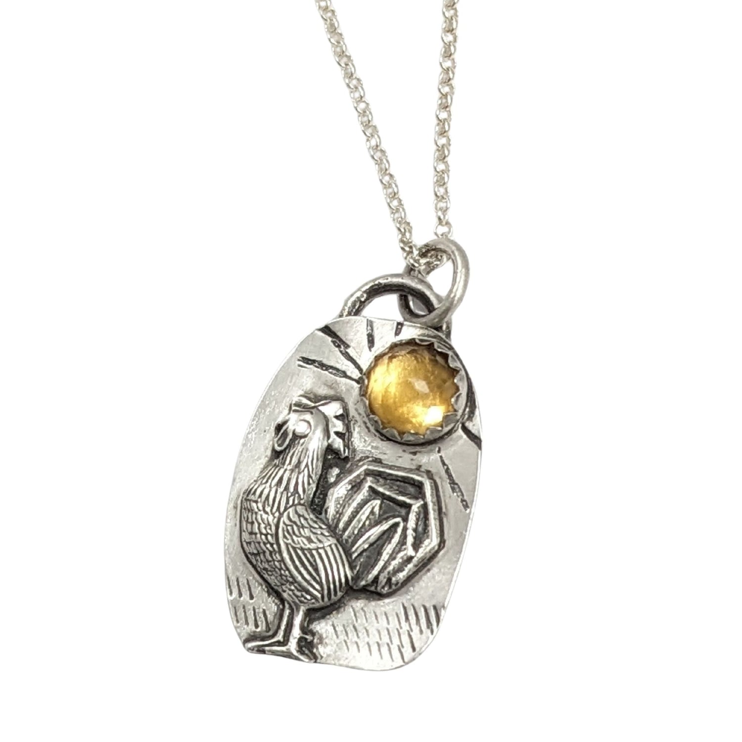 Sterling silver pendant with a three dimensional rooster and a yellow citrine gemstone on a textured background