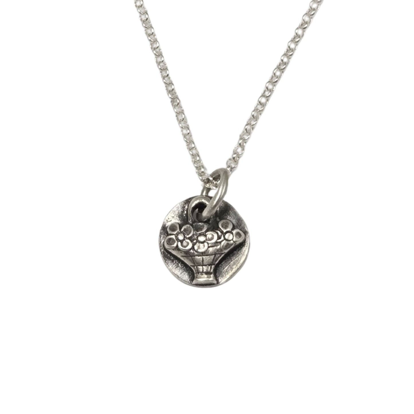 Necklace of a tiny hand basket full of flowers in silver.