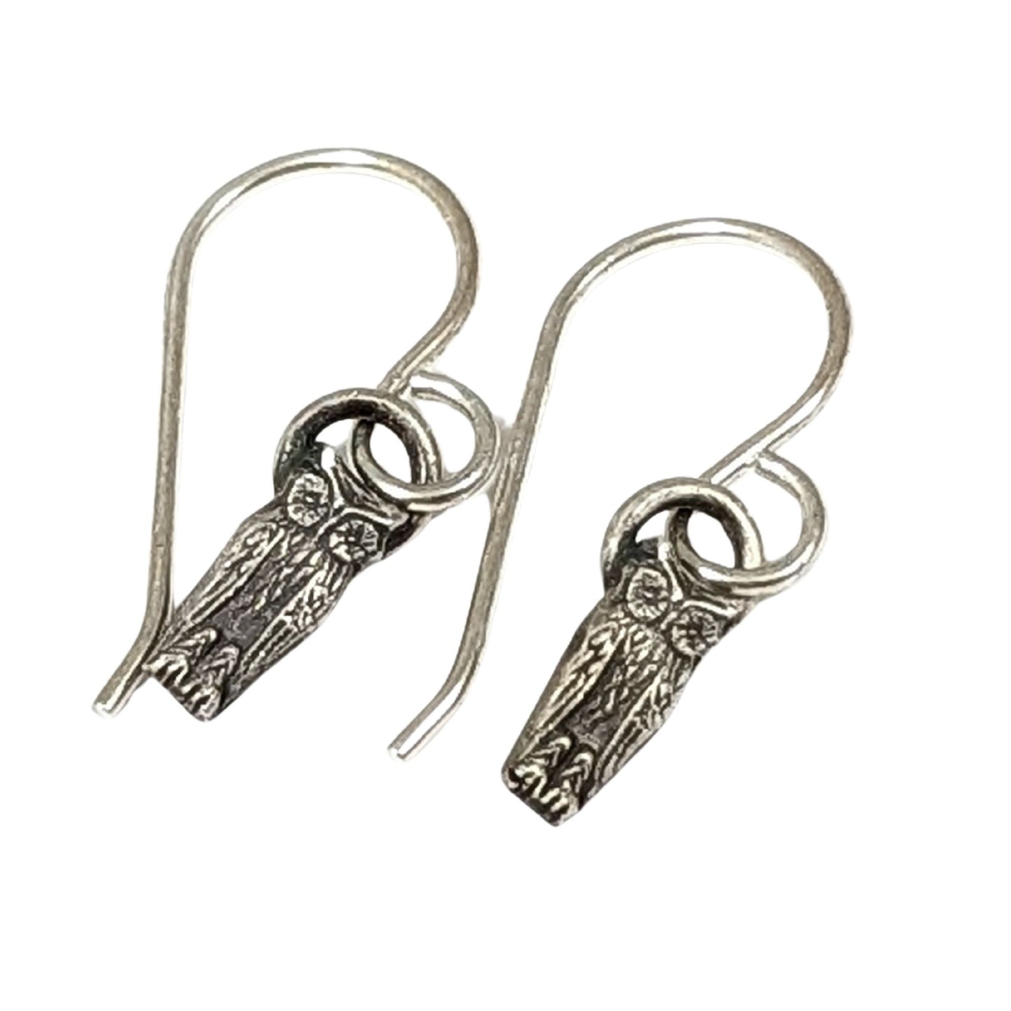 Pair of silver earrings with intricate designs on a white background