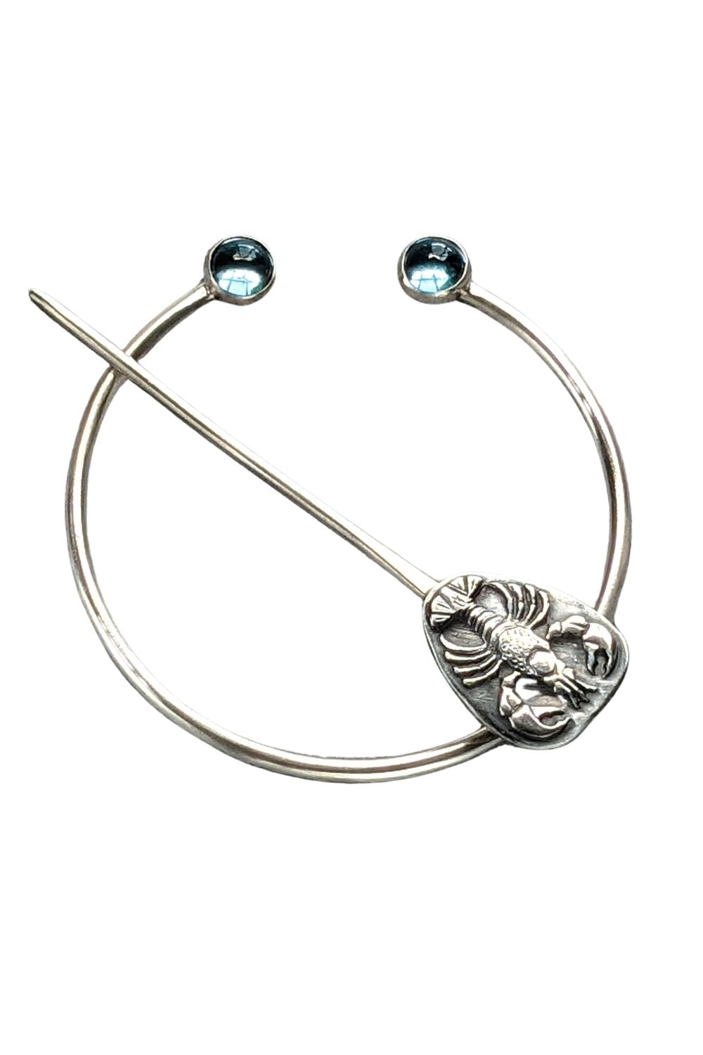 Sterling silver penannular brooch. The tip of the stem is decorated with a detailed dimensional lobster, and the ends of the loop have bright swiss blue topaz gemstone cabochons.