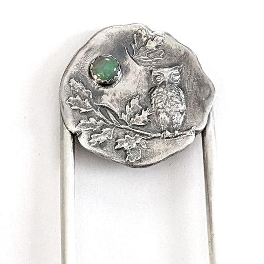 Sterling silver hair fork. The design at the top of the hair fork is a round sterling silver piece with a 3 dimensional design of an owl sitting on a tree branch. The branch has leaves, oak perhaps. Above the leaves there is a white opal gemstone to represent the moon.