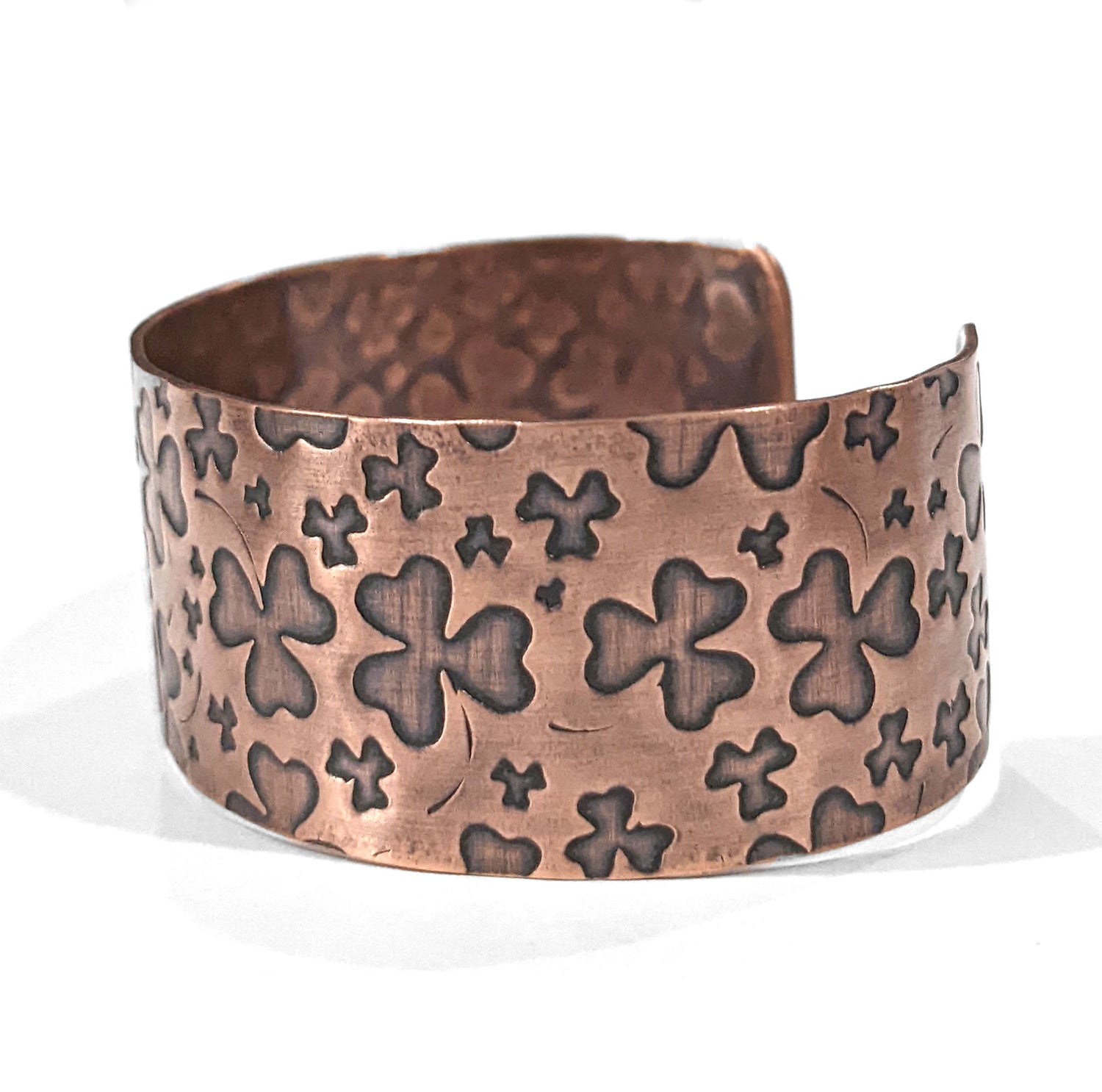 One inch wide copper cuff bracelet with impressions of shamrocks. 