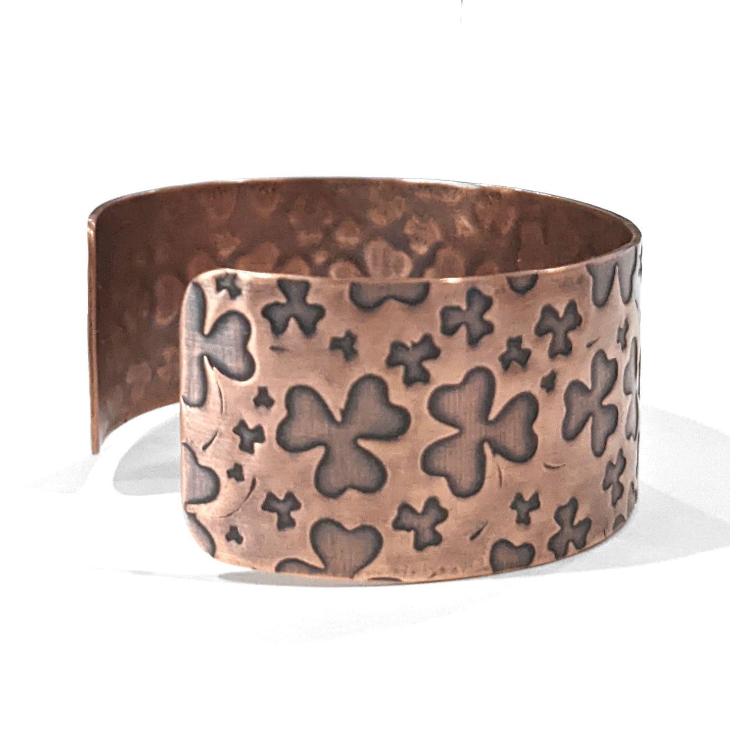 One inch wide copper cuff bracelet with impressions of shamrocks. 