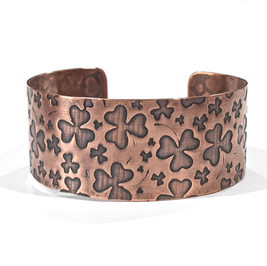 One inch wide copper cuff bracelet with impressions of shamrocks.