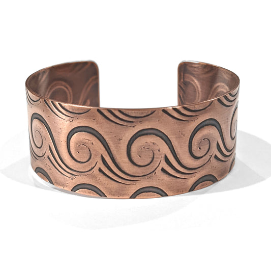 Copper cuff bracelet with a series of abstract line waves that wrap the entire cuff. Meant to resemble an ocean wave.