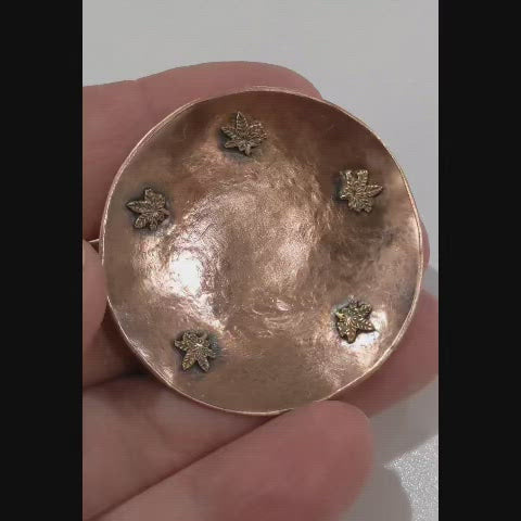Cannabis Leaf Copper Bowl for rings, jewelry, trinkets. This small bowl has hammered texture and raised edges. Toward the edge of the bowl are five bronze cannabis leaves that are soldered to the copper.