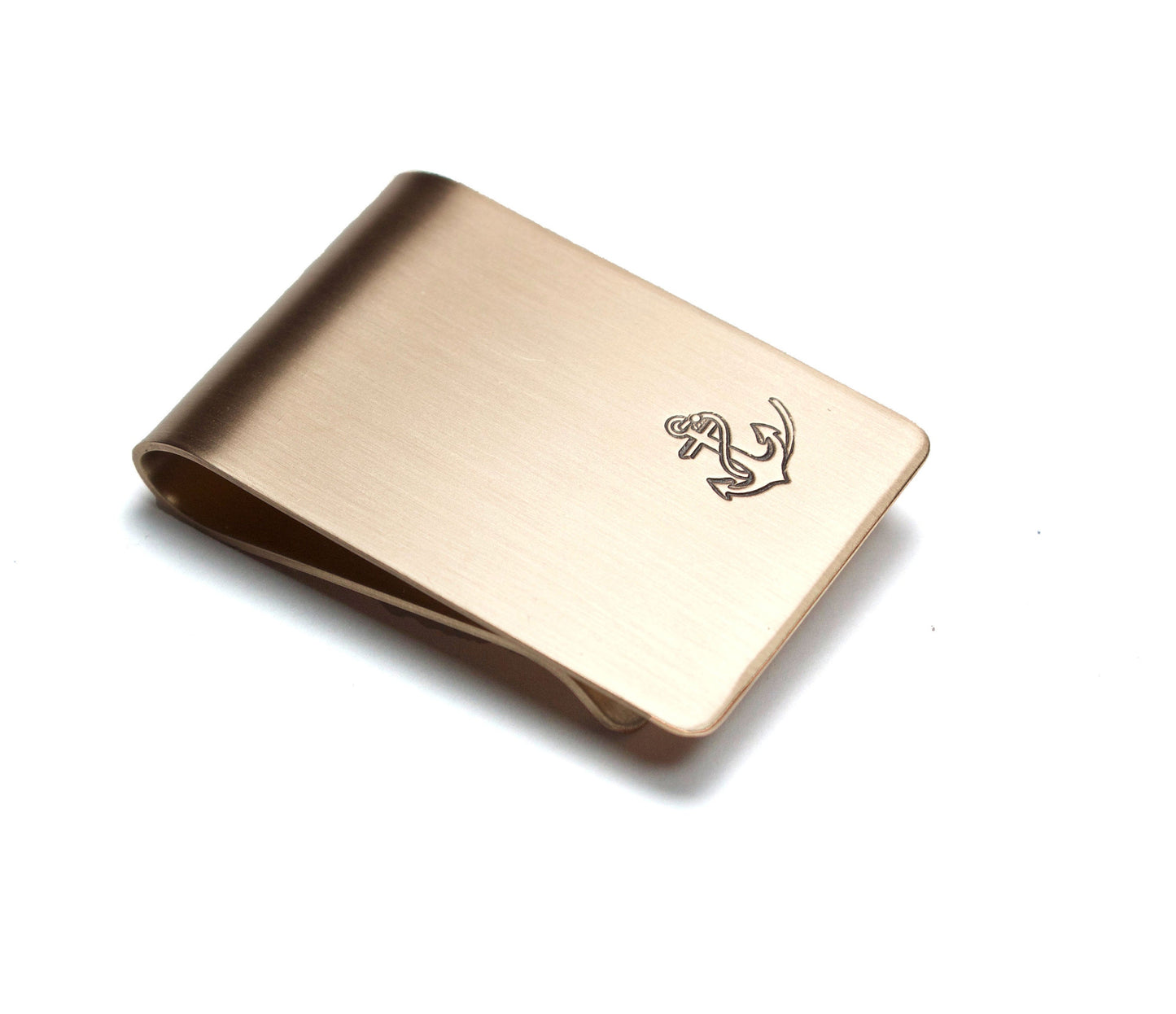 Anchor and Rope Money Clip. A small money clip with a stamped image of a boat anchor wrapped in a length of rope. The stamped design is darkened (oxidized). The money clip is shown in bronze metal.