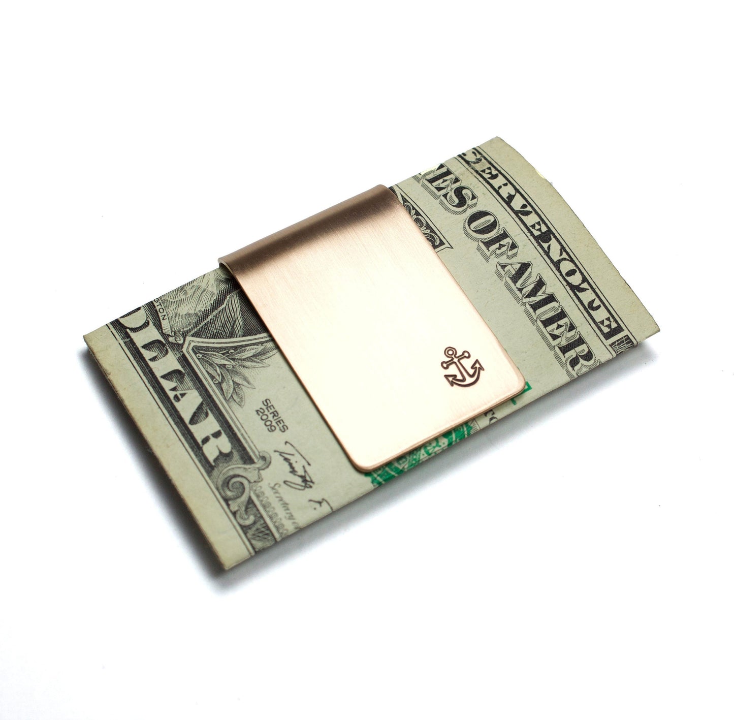 Anchor and Rope Money Clip. A small money clip with a stamped image of a boat anchor. The stamped design is darkened (oxidized). The money clip is shown in bronze metal.