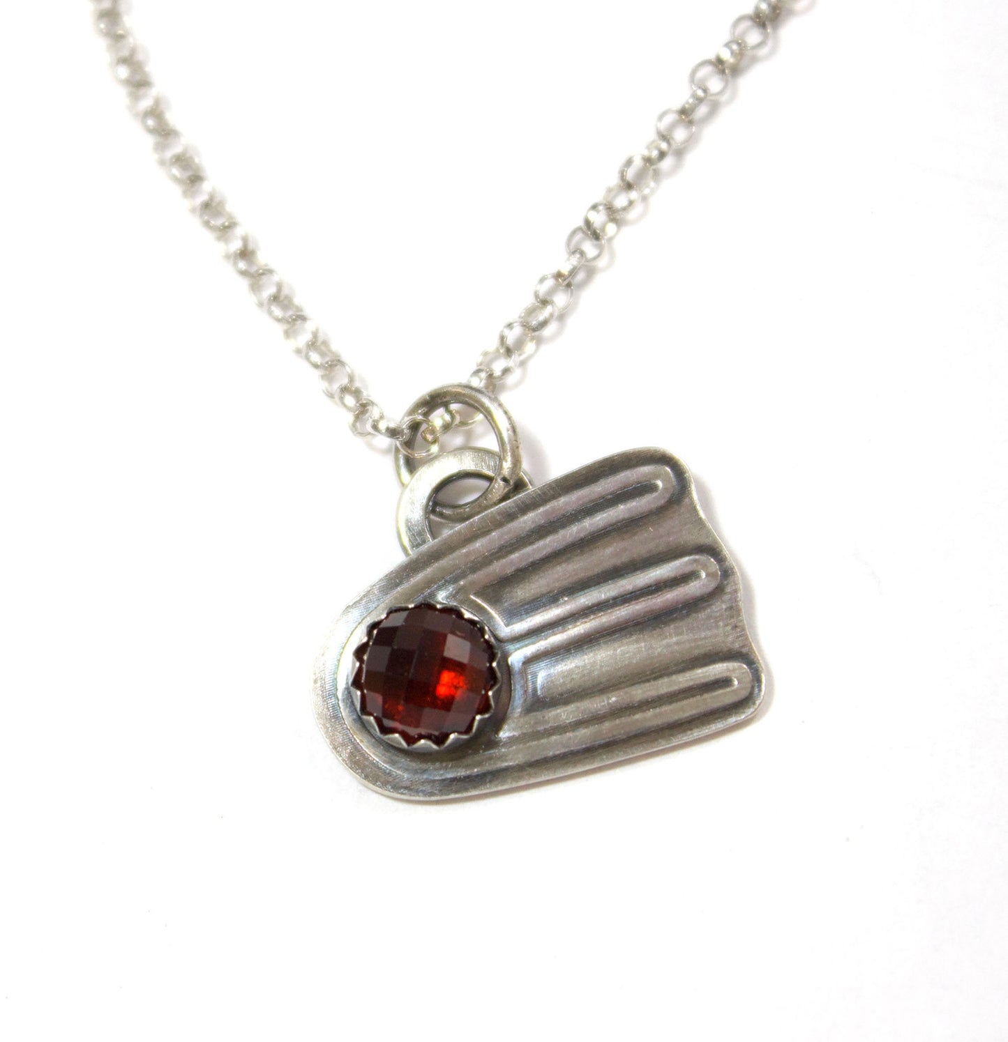 Comet shaped sterling silver pendant with a rose cut red garnet