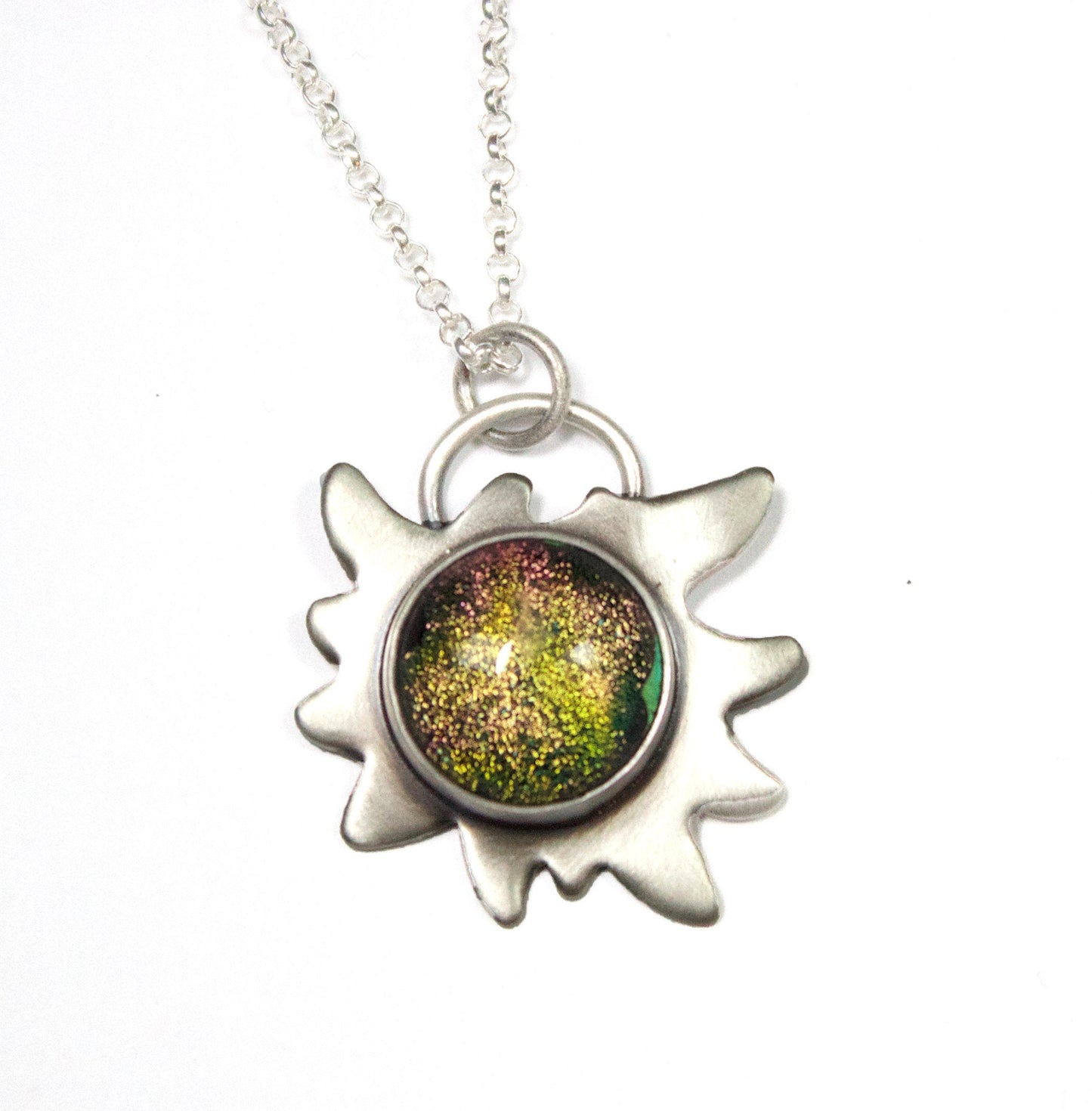 Edelweiss Flower Glass Stone Galaxy Pendant. This a one inch wide pendant made in sterling silver. The center is dichroic glass with sparkling bits in a golden color. The silver is shoped like an edelweiss flower. The sterling silver pendant comes on a rolo chain.