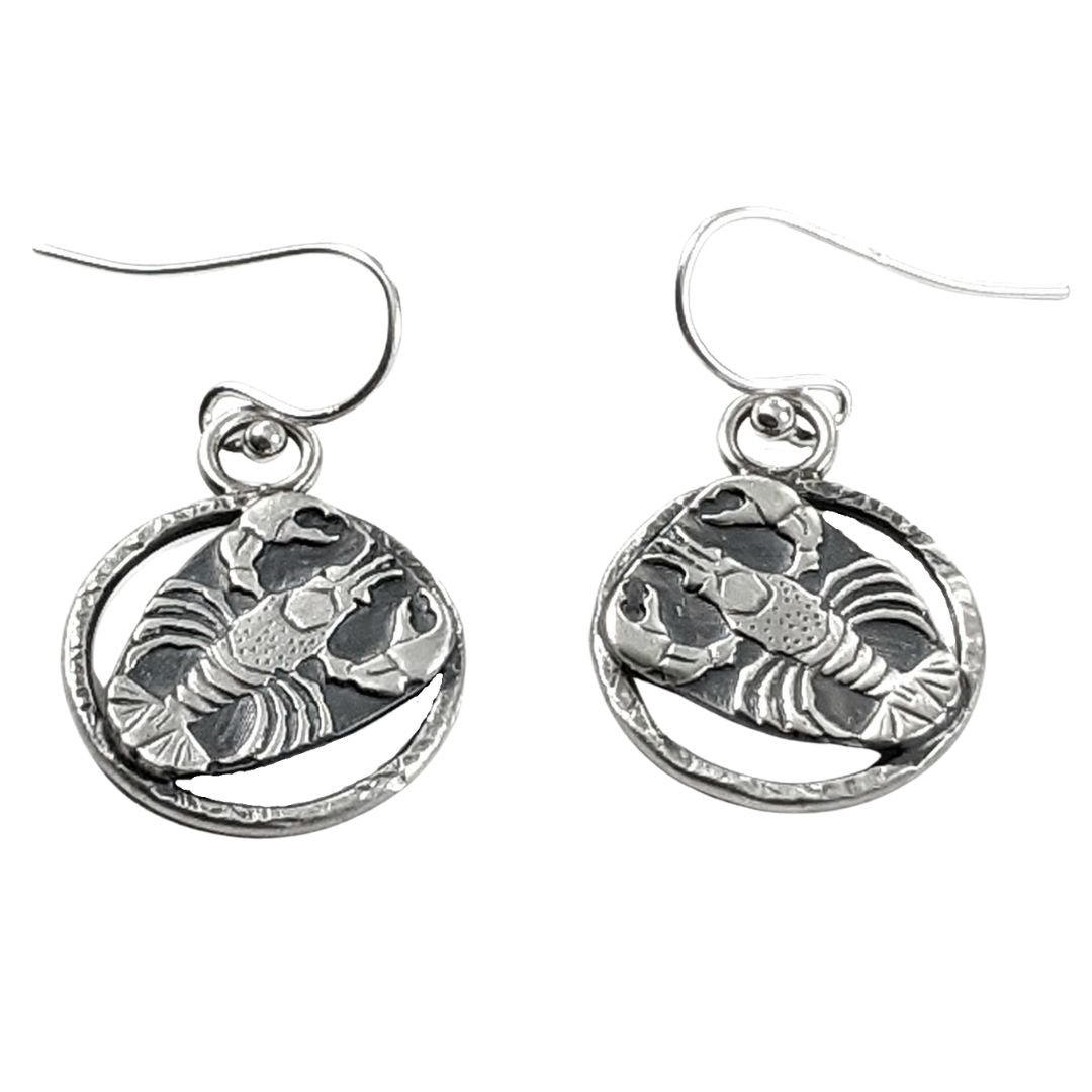 Sterling silver lobster earrings. The lobster is a detailed raised impression and is attached to a sterling open hoop that has a hammered texture design.